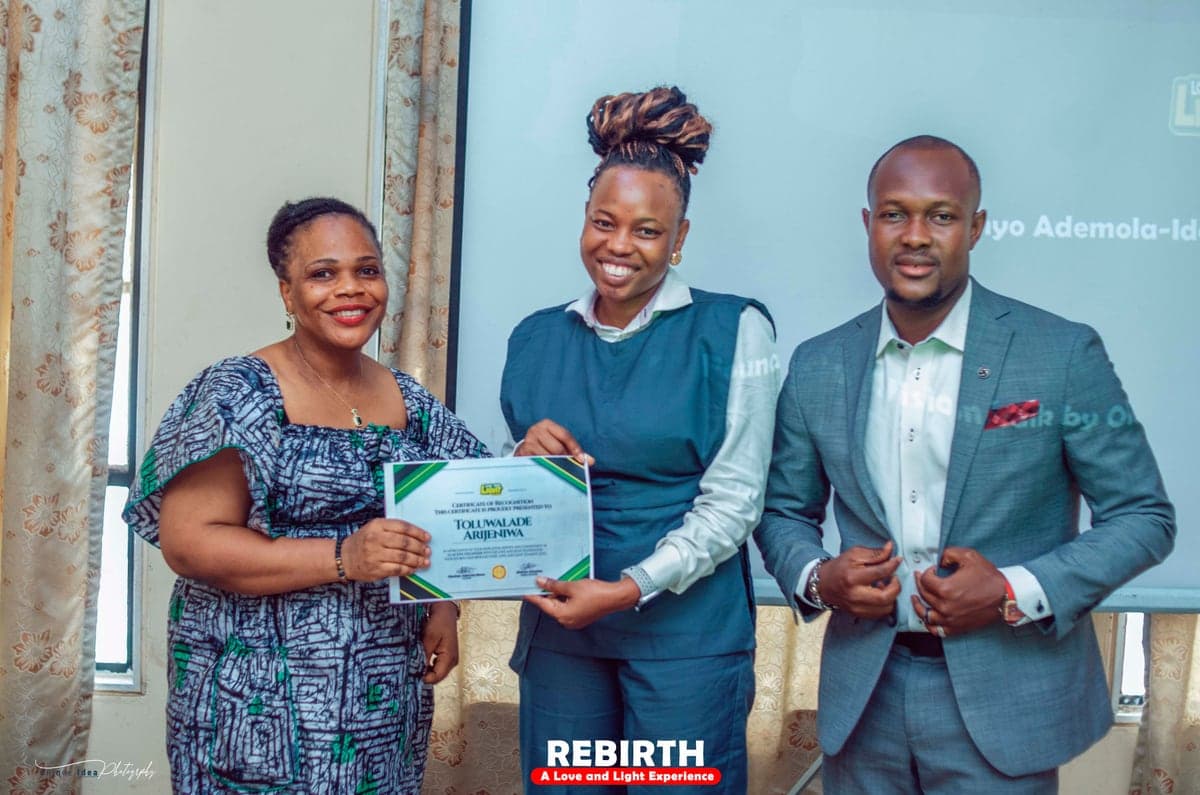 Toluwalade Arijeniwa receiving a Love & Light Foundation certificate of recognition